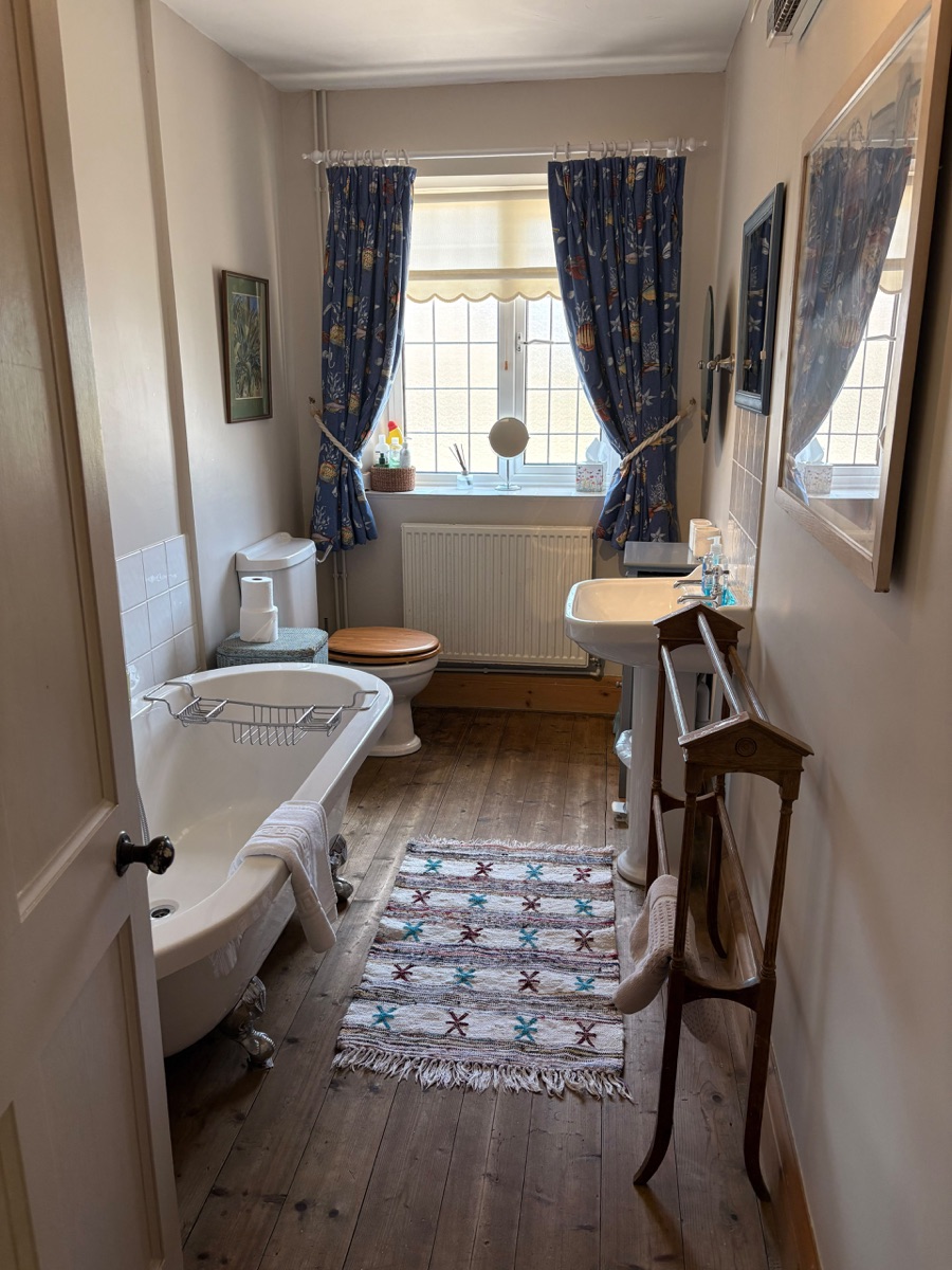 Bathroom with a freestanding roll-top bath and wooden floor