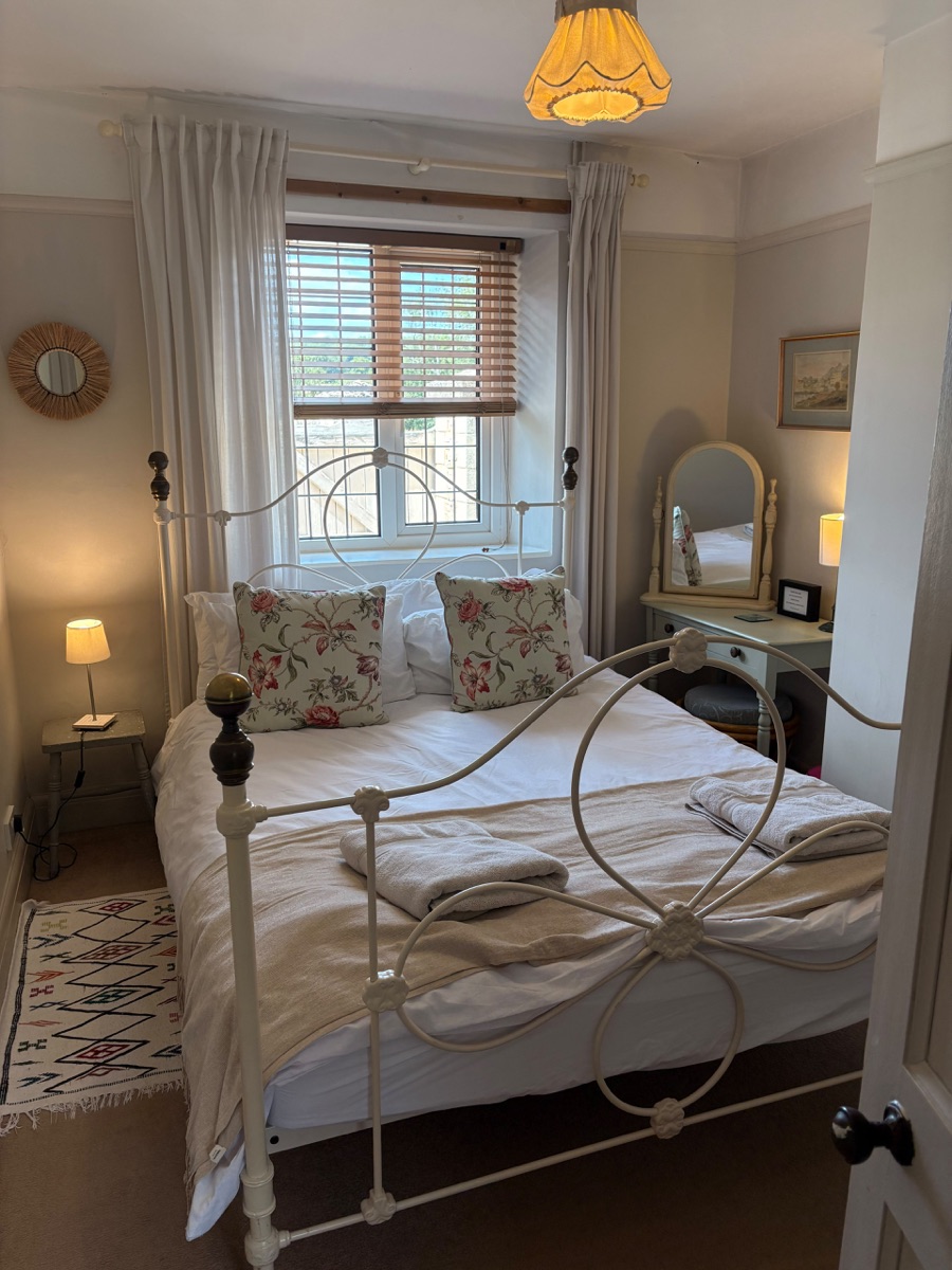 Second bedroom with king-size bed and floral cushions